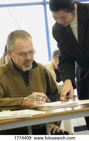 Teacher helping adult student View Large Photo Image Stock Photo - Teacher helping adult student. Fotosearch