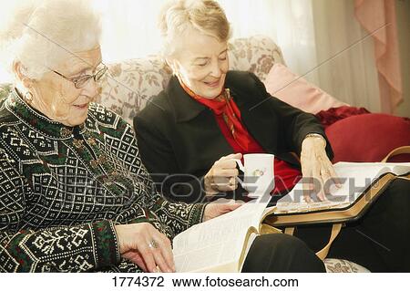 Stock Image - Two older women reading bible. Fotosearch