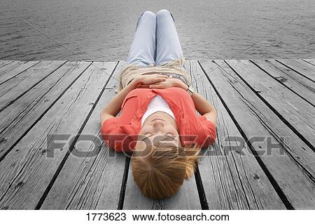 Woman lying on dock View Large Photo Image Stock Image - Woman lying on dock. Fotosearch