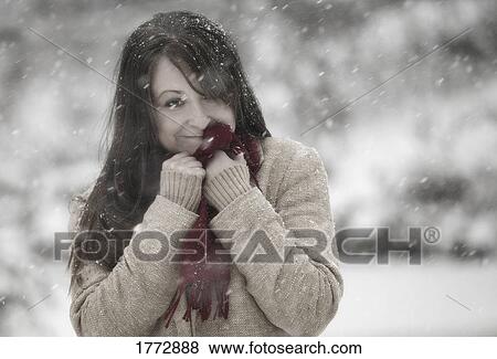 Stock Photo - Woman standing outside in snow. Fotosearch
