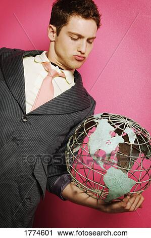 Young businessman with globe in hand View Large Photo Image Stock Image - Young businessman with globe in hand. Fotosearch