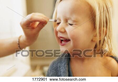 Young girl putting on makeup View Large Photo Image Stock Image - Young girl putting on makeup. Fotosearch