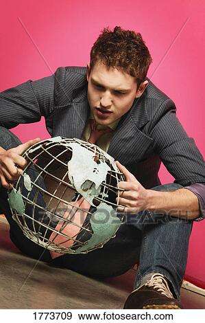 Young man holding globe View Large Photo Image Stock Photo - Young man holding globe. Fotosearch