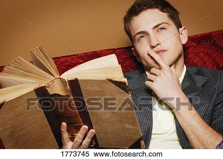 Young man reading book View Large Photo Image Stock Photography - Young man reading book. Fotosearch