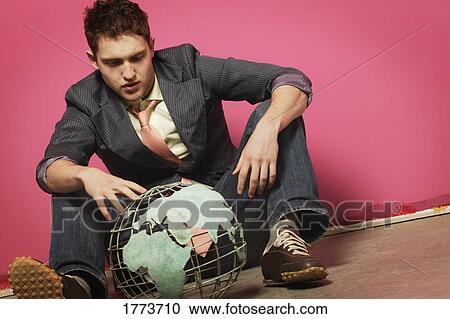 Stock Image - young man with globe. Fotosearch