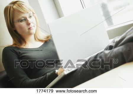 Stock Photo - Young woman working on laptop. Fotosearch