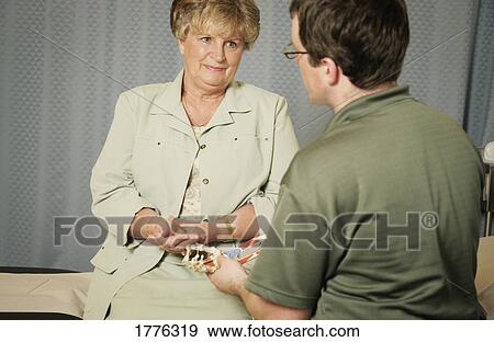 A physiotherapist talks to a patient View Large Photo Image Stock Photo - A physiotherapist talks to a patient. Fotosearch