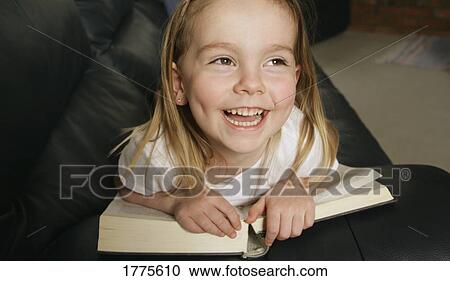 Stock Image - A young girl enjoying her book. Fotosearch