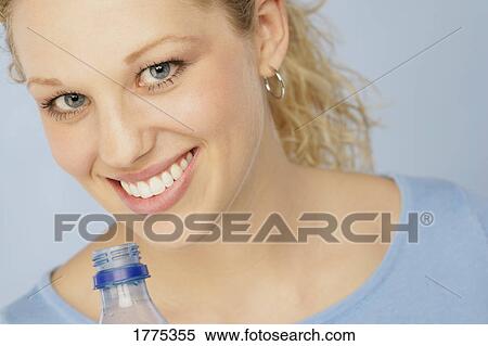 Stock Photography - Beautiful blonde teenager with plastic bottle. Fotosearch
