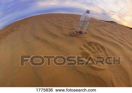 Bottle of water in the sand View Large Photo Image Stock Photograph - Bottle of water in the sand. Fotosearch