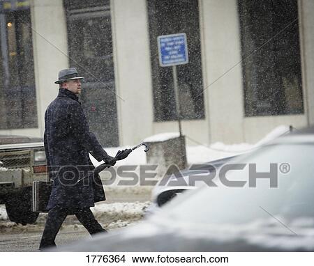 Picture - Businessman crossing a wintry road. Fotosearch