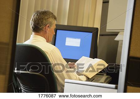 Businessman reading Bible in office View Large Photo Image Stock Photo - Businessman reading Bible in office. Fotosearch
