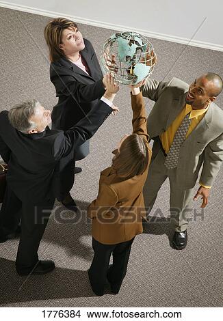 Businesspeople holding globe View Large Photo Image Picture - Businesspeople holding globe. Fotosearch