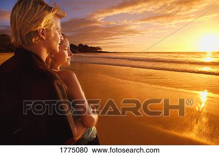 Couple sharing a romantic sunset on a beach View Large Photo Image Stock Image - Couple sharing a romantic sunset on a beach. Fotosearch