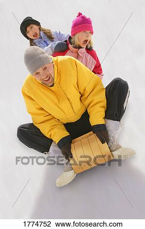 Father and daughters on sled View Large Photo Image Stock Image - Father and daughters on sled. Fotosearch