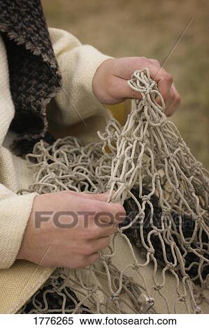 Stock Photography - Fisherman working on a net. Fotosearch