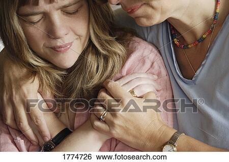 Girl receiving a hug from older lady View Large Photo Image Stock Photograph - Girl receiving a hug from older lady. Fotosearch