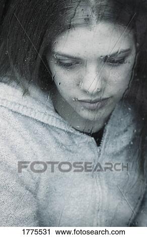 Stock Image - Girl watching the rain. Fotosearch