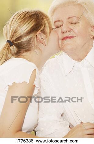 Stock Photograph - Granddaughter kissing grandma. Fotosearch