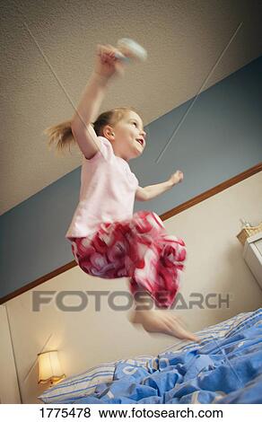 Stock Photo - Jumping on the bed. Fotosearch