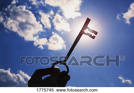 Stock Photography - Key held up in sky. Fotosearch