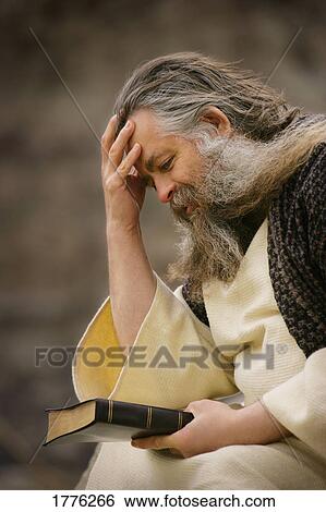 Man holding the Bible and thinking View Large Photo Image Stock Photograph - Man holding the Bible and thinking. Fotosearch