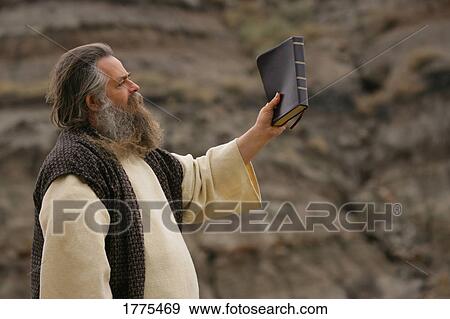 Stock Photo - Man holding up Bible. Fotosearch