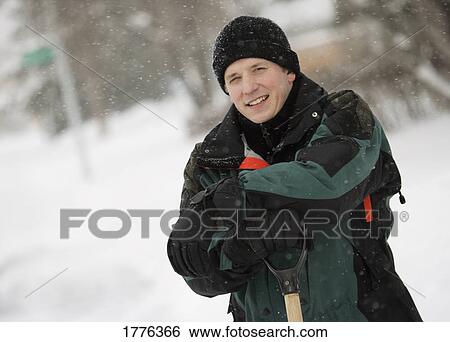 Man leaning on shovel in the snow View Large Photo Image Stock Photograph - Man leaning on shovel in the snow. Fotosearch