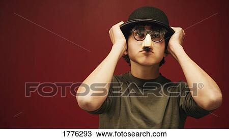 Man wearing a bowler hat and mask View Large Photo Image Stock Image - Man wearing a bowler hat and mask. Fotosearch