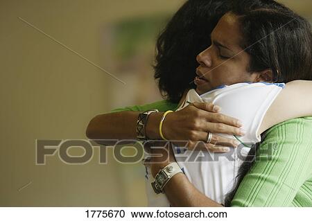 Stock Image - Pair of girls in supportive hug. Fotosearch