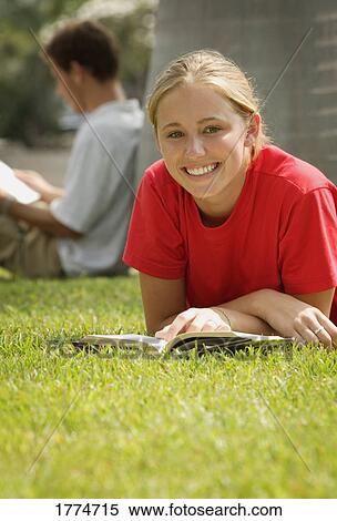Stock Photography - Pretty teenage student reading outdoors. Fotosearch
