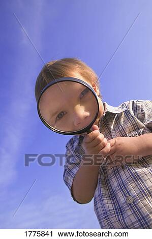 Stock Image - Small boy with magnifying glass. Fotosearch