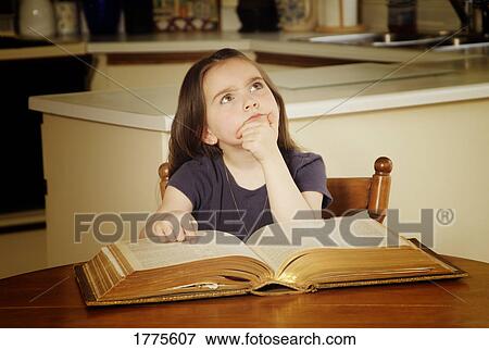 Stock Photo - Small girl reading and wondering. Fotosearch