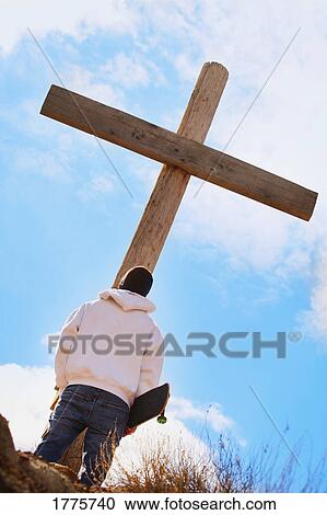 Stock Image - Teenager searching for answers at the cross. Fotosearch