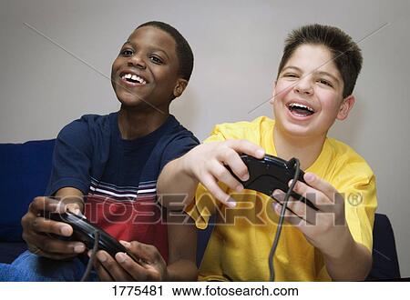 Two boys playing a video game View Large Photo Image Stock Image - Two boys playing a video game. Fotosearch