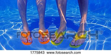 Stock Image - Two pairs of legs in a pool. Fotosearch