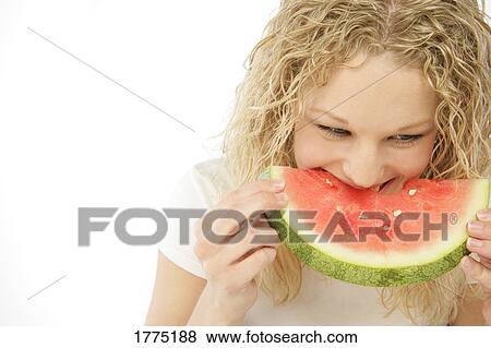 Stock Photo - Woman enjoying a slice of watermelon. Fotosearch