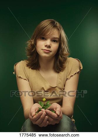 Stock Photography - Young girl holding a young plant. Fotosearch
