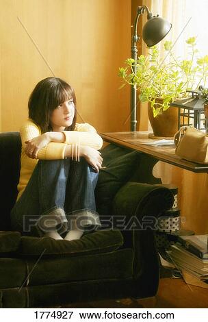 Young girl sitting by the window View Large Photo Image Stock Photo - Young girl sitting by the window. Fotosearch