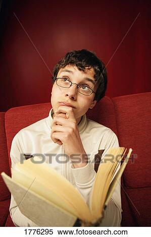 Stock Photography - Young man contemplating what he has read. Fotosearch