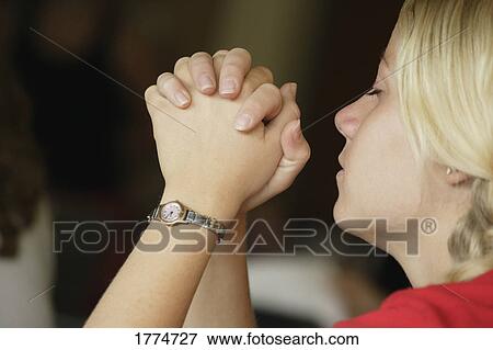 Stock Photo - Young woman praying. Fotosearch