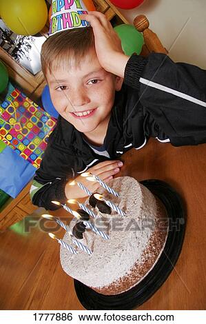 Stock Photograph - A child with a his birthday cake. Fotosearch