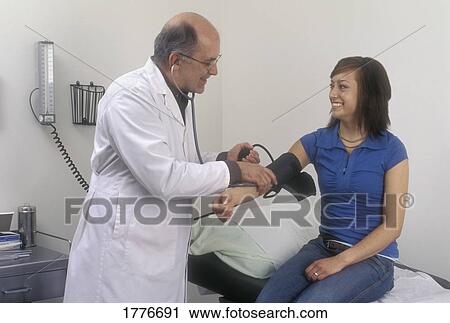 A doctor checking a patient's blood pressure View Large Photo Image Stock Image - A doctor checking a patient's blood pressure. Fotosearch