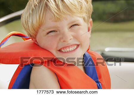 Stock Image - A happy little boy wearing a life jacket. Fotosearch