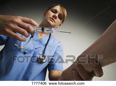 A nurse administering an injection View Large Photo Image Stock Photograph - A nurse administering an injection. Fotosearch