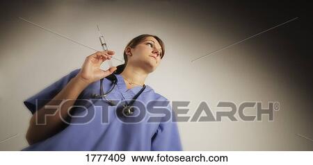 A nurse holding a medical needle View Large Photo Image Stock Photo - A nurse holding a medical needle. Fotosearch