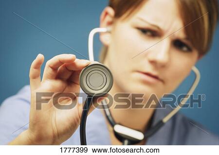 Stock Photo - A nurse or doctor listening with a stethoscope. Fotosearch