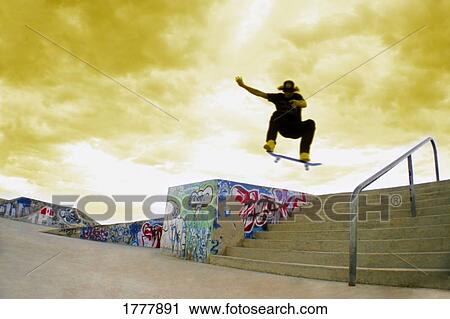 A skater performing tricks in a skate park (skatepark) View Large Photo Image Stock Image - A skater performing tricks in a skate park (skatepark). Fotosearch