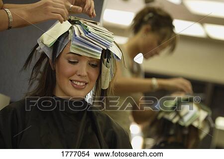 A stylist removing the foils from a woman's hair View Large Photo Image Picture - A stylist removing the foils from a woman's hair. Fotosearch