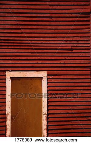 A worn door set in a red wooden wall View Large Photo Image Stock Photo - A worn door set in a red wooden wall. Fotosearch
